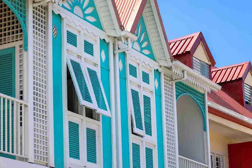 Coastal home with blue angled Bahama shutters, highlighting ventilation and shade benefits in Bahama vs Colonial shutters