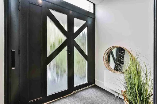 Sleek black front door with frosted glass panels and minimalist entryway design inspired by modern Front Door Trends.