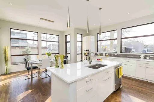 A modern kitchen with multiple fixed windows allowing natural light through picture windows