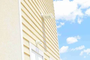 Light yellow horizontal siding on home exterior, illustrating material comparison in James Hardie vs vinyl siding.