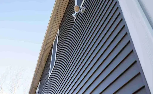 Dark gray vertical siding on residential exterior, comparing durability and texture in James Hardie vs vinyl siding.