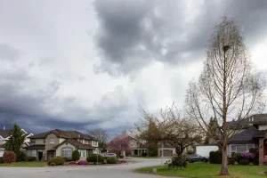Florida neighborhood under storm clouds highlighting wind mitigation inspection Florida preparation benefits.
