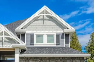 James Hardie siding colors in light gray with white trim, decorative gables, and matching architectural shingles.