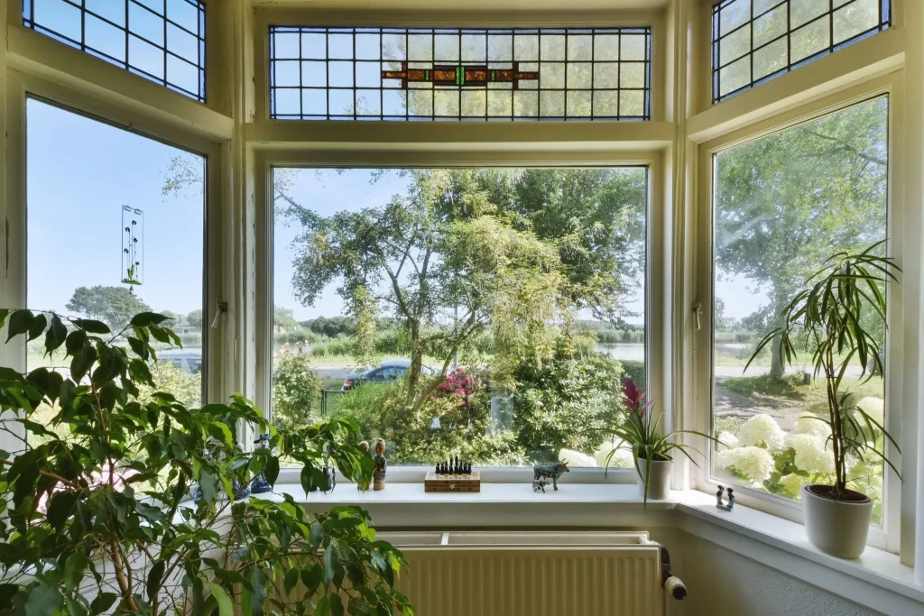 Picture window replacement Florida example with a large central window surrounded by plants and garden views